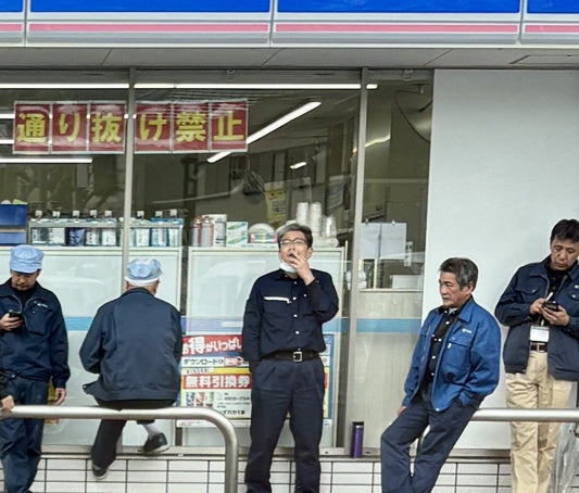 Lawson convenience store workers in Japan taking a smoke and phone break outside the storefront