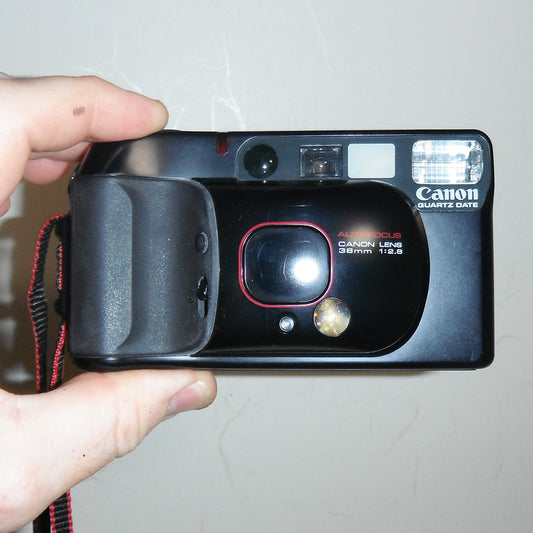 Front view of Canon Autoboy 3 (SureShot Supreme) 35mm film camera with lens cover closed