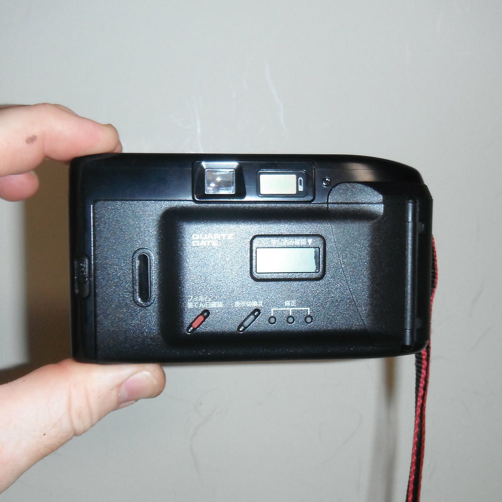 Rear of the camera with viewfinder, film door, and control layout